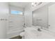 Clean bathroom with shower-tub combination, white vanity, and a bright accent window at 2762 S 357Th Dr, Tonopah, AZ 85354