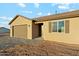 Tan home showcasing a two-car garage and desert landscaping for a modern look at 2762 S 357Th Dr, Tonopah, AZ 85354
