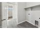 Practical laundry room with gray tile floor and shelving with in-wall water and drain attachments at 2762 S 357Th Dr, Tonopah, AZ 85354