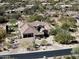 Beautiful desert home showcased from above with red tile roofing, desert landscaping, and hardscaped driveway at 27728 N 68Th Pl, Scottsdale, AZ 85266