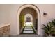 Covered entryway featuring stone pavers, decorative plants, and a view of the front door at 27728 N 68Th Pl, Scottsdale, AZ 85266