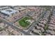 Aerial view of a residential neighborhood with a playground, trees, and apartment buildings in the distance at 2983 E Harrison St, Gilbert, AZ 85295