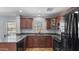 Well-lit kitchen featuring granite countertops, wooden cabinets, and modern black appliances at 2983 E Harrison St, Gilbert, AZ 85295