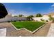 A serene backyard featuring a manicured lawn bordered by gravel and a low wall, offering a private outdoor space at 3392 E Gemini Ct, Chandler, AZ 85249