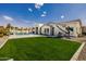 Beautifully landscaped backyard featuring a well-manicured lawn, built-in grill, and tiled patio leading to a sparkling pool at 3392 E Gemini Ct, Chandler, AZ 85249