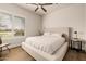 Bright bedroom with a ceiling fan, neutral tones, and a large window with plantation shutters at 3392 E Gemini Ct, Chandler, AZ 85249