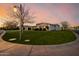 Scenic view of the front yard featuring a vibrant green lawn and a beautifully lit street lamp at dusk at 3392 E Gemini Ct, Chandler, AZ 85249