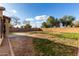 An expansive backyard with a small concrete patio and a perimeter brick wall at 3424 E Flamingo Ct, Gilbert, AZ 85297