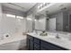 Well-lit bathroom featuring double sinks, a combination tub and shower, and modern fixtures at 3424 E Flamingo Ct, Gilbert, AZ 85297