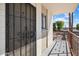 Inviting condo entry with secure metal gate, brick facade, and private balcony overlooking a pool at 3737 E Turney Ave # 206, Phoenix, AZ 85018