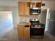 View of the kitchen featuring a stove, microwave, cabinets, and granite countertops at 4221 N 33Rd Dr, Phoenix, AZ 85017