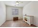 Spare bedroom featuring a ceiling fan, wood-look flooring, and a bright window at 42808 W Whimsical Dr, Maricopa, AZ 85138