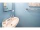 Powder room with a pedestal sink, chrome fixtures, and blue painted walls at 4610 N 68Th St # 402, Scottsdale, AZ 85251