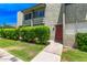 Exterior view of a condo building with textured walls, trimmed bushes, and a well-maintained lawn at 4610 N 68Th St # 402, Scottsdale, AZ 85251