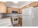 Modern kitchen with wood cabinets, a white refrigerator, and a full appliance suite for comfortable living at 4610 N 68Th St # 402, Scottsdale, AZ 85251