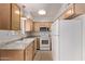 Well-lit kitchen showcasing wood cabinets, a white refrigerator, and essential appliances for convenient cooking at 4610 N 68Th St # 402, Scottsdale, AZ 85251