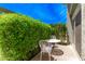Cozy patio space featuring a white wrought iron table and chairs surrounded by lush greenery at 4610 N 68Th St # 402, Scottsdale, AZ 85251