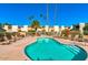 Relaxing pool area with lounge chairs and clear blue water is surrounded by palm trees and townhome buildings at 4610 N 68Th St # 402, Scottsdale, AZ 85251