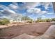 Backyard landscaping with desert trees and a border wall along a textured patio surface at 529 S Val Vista Rd, Apache Junction, AZ 85119