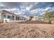 Spacious, dirt backyard with white exterior and patio, under a cloudy sky at 529 S Val Vista Rd, Apache Junction, AZ 85119