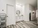 Bright bathroom featuring wood-style floors, white walls, white cabinets, and a black round mirror at 529 S Val Vista Rd, Apache Junction, AZ 85119