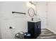 Bathroom featuring a black vanity, round mirror, toilet paper holder, and wood-style floors at 529 S Val Vista Rd, Apache Junction, AZ 85119