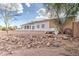 A single story house with a yard of dirt and rocks under a partly cloudy sky at 529 S Val Vista Rd, Apache Junction, AZ 85119