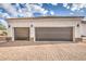 Three-car garage with brick driveway and dark brown doors at 529 S Val Vista Rd, Apache Junction, AZ 85119