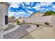 Serene backyard with brick-paved patio, gravel landscaping, and a winding walkway at 6664 W Rose Garden Ln, Glendale, AZ 85308