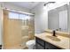 Bathroom featuring a glass-enclosed shower, vanity with dark cabinets, and decorative mirror at 6664 W Rose Garden Ln, Glendale, AZ 85308