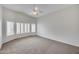 Bright, open bedroom with plantation shutters, carpet, and a ceiling fan at 6664 W Rose Garden Ln, Glendale, AZ 85308