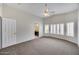 Spacious bedroom featuring plantation shutters, carpet, ceiling fan, and ensuite bathroom at 6664 W Rose Garden Ln, Glendale, AZ 85308