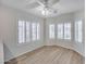 Sunlit dining area with sleek wood floors, modern ceiling fan, and shuttered windows at 6664 W Rose Garden Ln, Glendale, AZ 85308