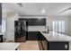 Modern kitchen with black cabinets, white countertops, stainless steel appliances and tile flooring at 6664 W Rose Garden Ln, Glendale, AZ 85308