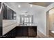 Bright kitchen with quartz countertops, stainless dishwasher, and black cabinets at 6664 W Rose Garden Ln, Glendale, AZ 85308