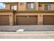 Row of garages with brown doors and stone accents at the base at 705 W Queen Creek Rd # 1059, Chandler, AZ 85248