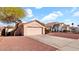 A beige garage door is featured on a single story home with desert landscaping at 9230 W Charleston Ave, Peoria, AZ 85382