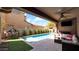 Backyard pool, covered patio with seating and playhouse on turf at 9282 E Desert Vw, Scottsdale, AZ 85255