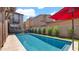 A backyard pool surrounded by turf with a red umbrella providing shade at 9282 E Desert Vw, Scottsdale, AZ 85255