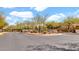 Street view of a gated community entrance showcasing lush desert landscaping and natural stone walls at 9282 E Desert Vw, Scottsdale, AZ 85255