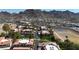 A wide aerial view featuring houses with well-manicured lawns, streets, and community tennis court set against a mountain backdrop at 10410 N Cave Creek Rd # 1032, Phoenix, AZ 85020