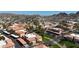 Aerial view showcasing red tile roofs amidst community landscaping and parking, with desert mountains in the background at 10410 N Cave Creek Rd # 1032, Phoenix, AZ 85020