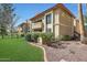 Building exterior with green grass, bushes, and a red rock border around the landscape at 10410 N Cave Creek Rd # 1032, Phoenix, AZ 85020