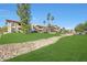 Exterior image with a rock drainage feature, mature landscaping, and palm trees at 10410 N Cave Creek Rd # 1032, Phoenix, AZ 85020