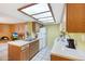 Kitchen features laminate counters, white appliances, and a light-filled skylight at 10410 N Cave Creek Rd # 1032, Phoenix, AZ 85020