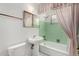 Vintage bathroom features a bathtub and shower combination, white fixtures, and green tiles at 1320 W Mariposa St, Phoenix, AZ 85013