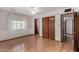 Bedroom with wood floors, a window with sheer curtains, and a closet with sliding doors at 1320 W Mariposa St, Phoenix, AZ 85013