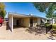 House with a brick paved driveway leading to a covered carport with a door and mature tree at 1320 W Mariposa St, Phoenix, AZ 85013