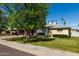 Charming home featuring a lush lawn, mature tree, and a covered carport, all under a clear blue sky at 1320 W Mariposa St, Phoenix, AZ 85013