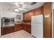 Retro kitchen with wood cabinets, stainless steel double oven, white appliances, and a vintage ceiling fan at 1320 W Mariposa St, Phoenix, AZ 85013